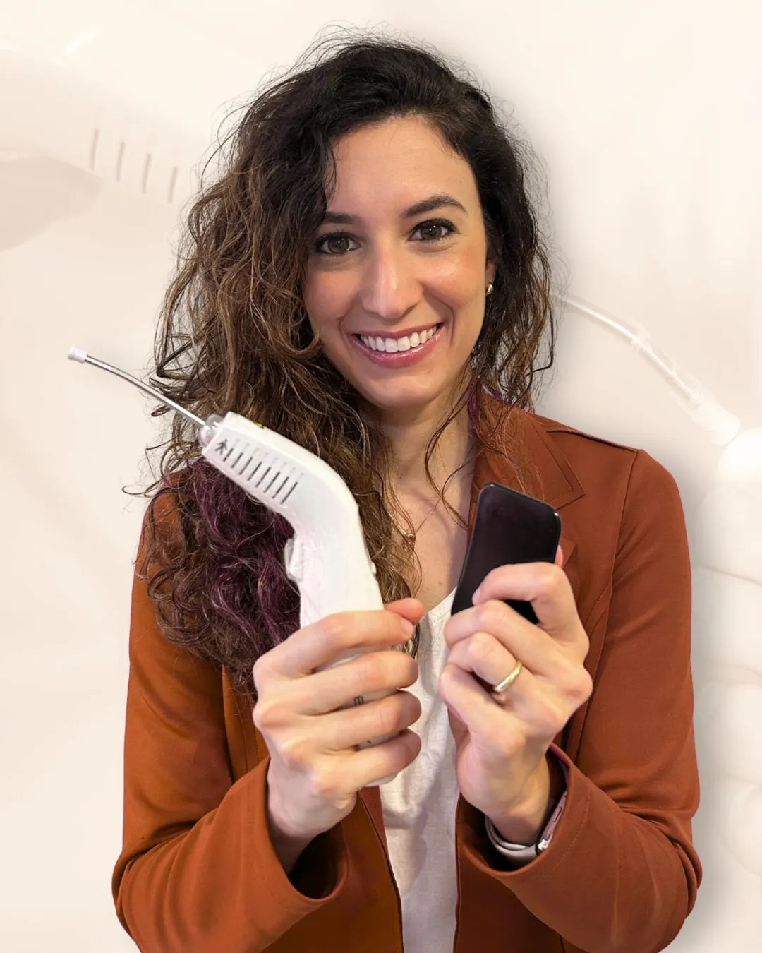 Fernanda Pradines com o equipamento de laser e celular